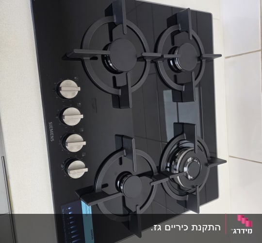 כיריים גז זכוכית שחורה מתוצרת סימנס המותקנות במשטח עבודה במטבח